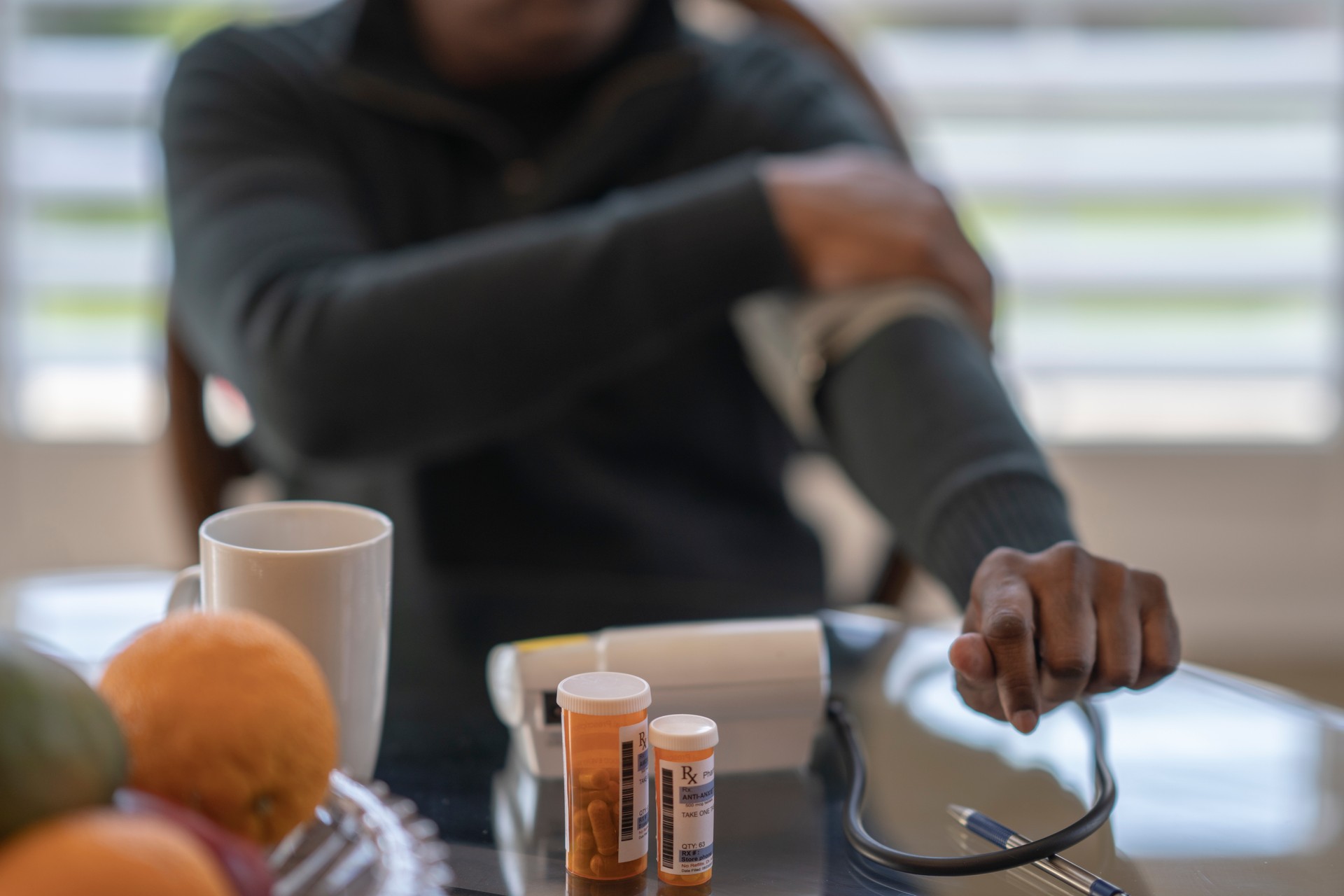 West Indian man checks his blood pressure at home